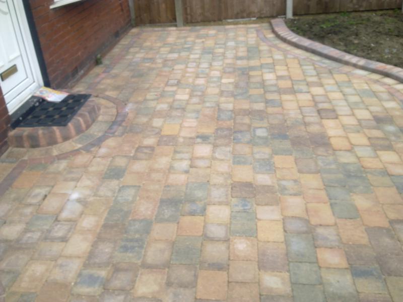 Small block paved driveway in mixed buff tones with a curved brick step