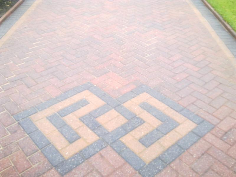 Block paved driveway with a decorative Greek key centre feature in buff and charcoal
