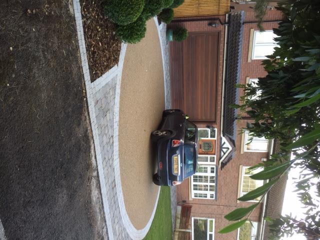 Resin bound driveway in warm gold aggregate with a granite sett border and turning circle